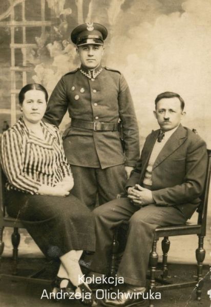 Żołnierz KOP znajduje się na środku, pomiędzy kobietą a mężczyzną. Zdjęcie pozowane.