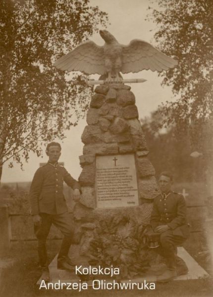 Trzech żołnierzy KOP pozuje do zdjęcia na tle pomnika poległych kopistów.