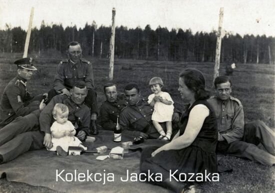 Żołnierze KOP w towarzystwie dzieci i kobiety. Zdjęcie w plenerze.