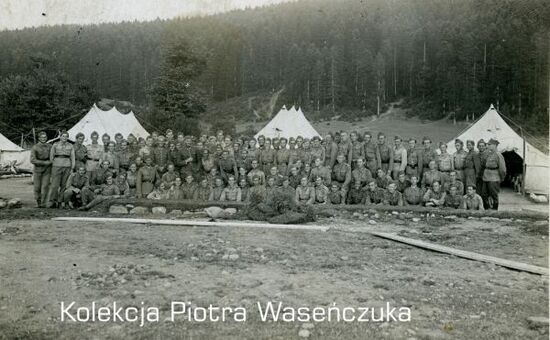 Zdjęcie pozowane dużej grupy żołnierzy KOP na tle obozu namiotowego.