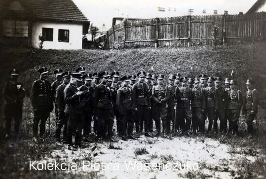 Grupa żołnierzy KOP- na drugim planie budynek oraz ogrodzenie