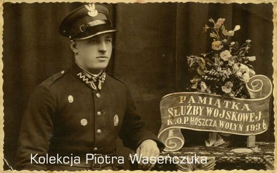Żołnierz KOP pozujący przy stoliku z kwiatami, napis &quot;Pamiątka służby wojskowej KOP Hoszcza, Wołyń, 1936 r.&quot;