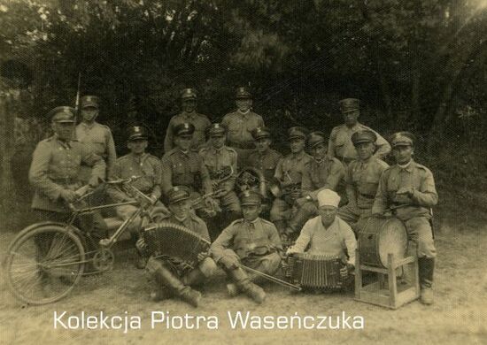 Grupa żołnierzy KOP pozująca z rowerem i instrumentami muzycznymi