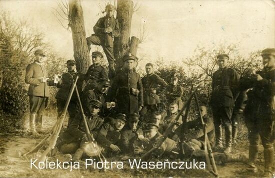 Grupa żołnierzy KOP na tle drzew, na pierwszym planie dwa trójnogi ustawione z karabinów